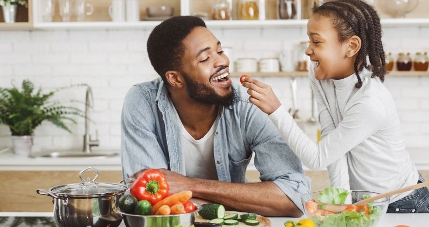 Pai e filha fazendo refeio na cozinha