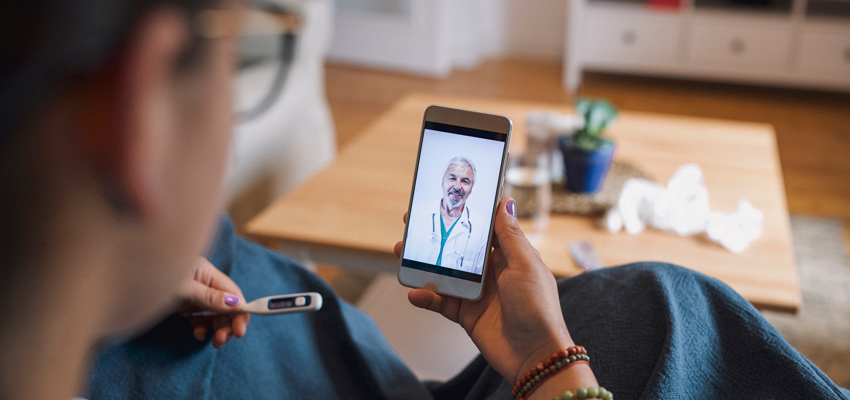 Mulher doente falando com um médico pelo celular através do pronto atendimento virtual