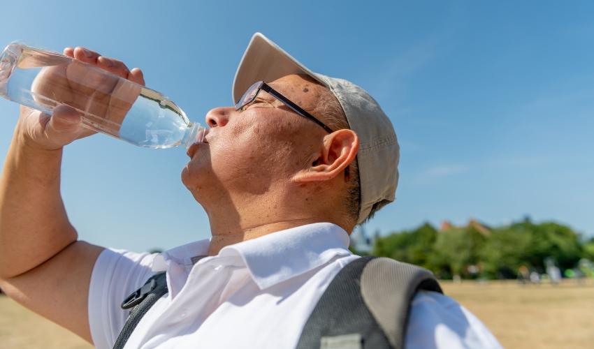 Homem bebendo agua para enfrentar calor excessivo