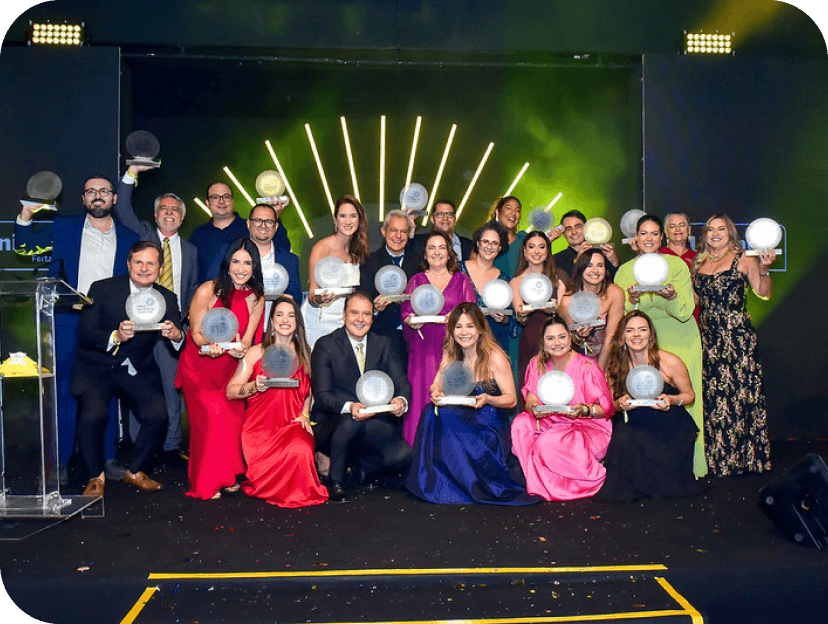 Pessoas com roupa de gala segurando o pr�mio.