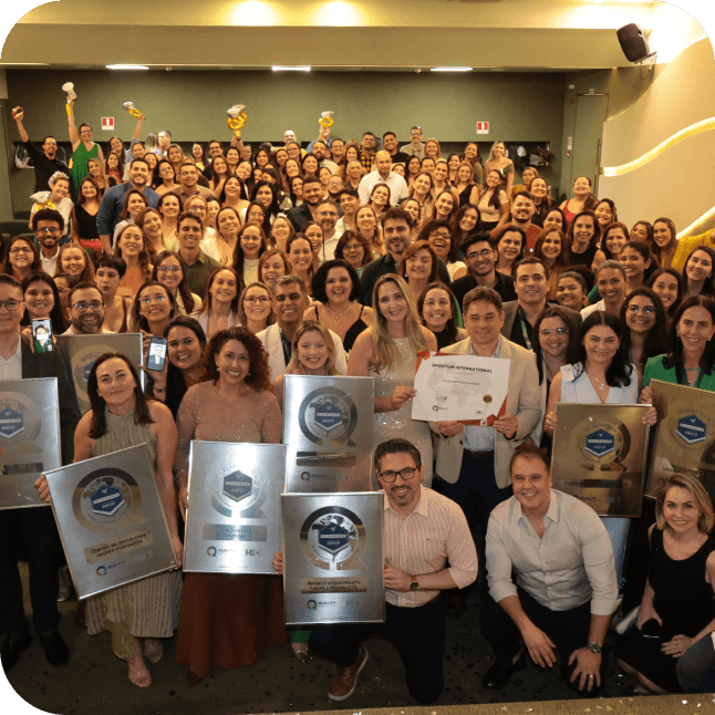 Muitas pessos juntas sorrindo pra a foto segurando um pr�mio