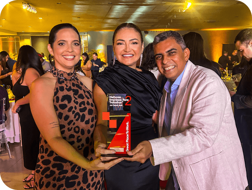 Tr�s pessoas em uma festa segurando um pr�mio